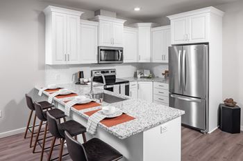 a kitchen with a marble counter top and stainless steel refrigerator at Expo, Minneapolis